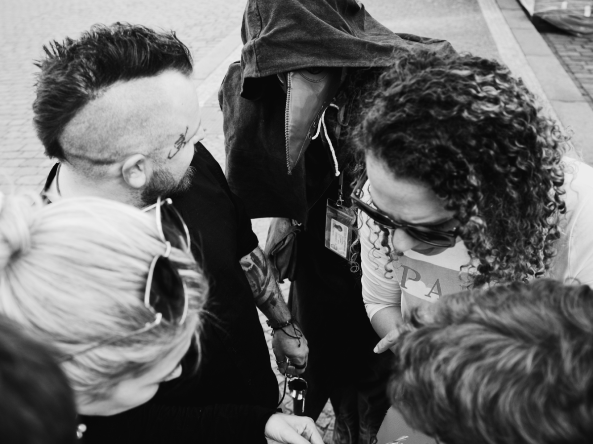 Private tour group is trying to solve the riddle with the Plague doctor checking.